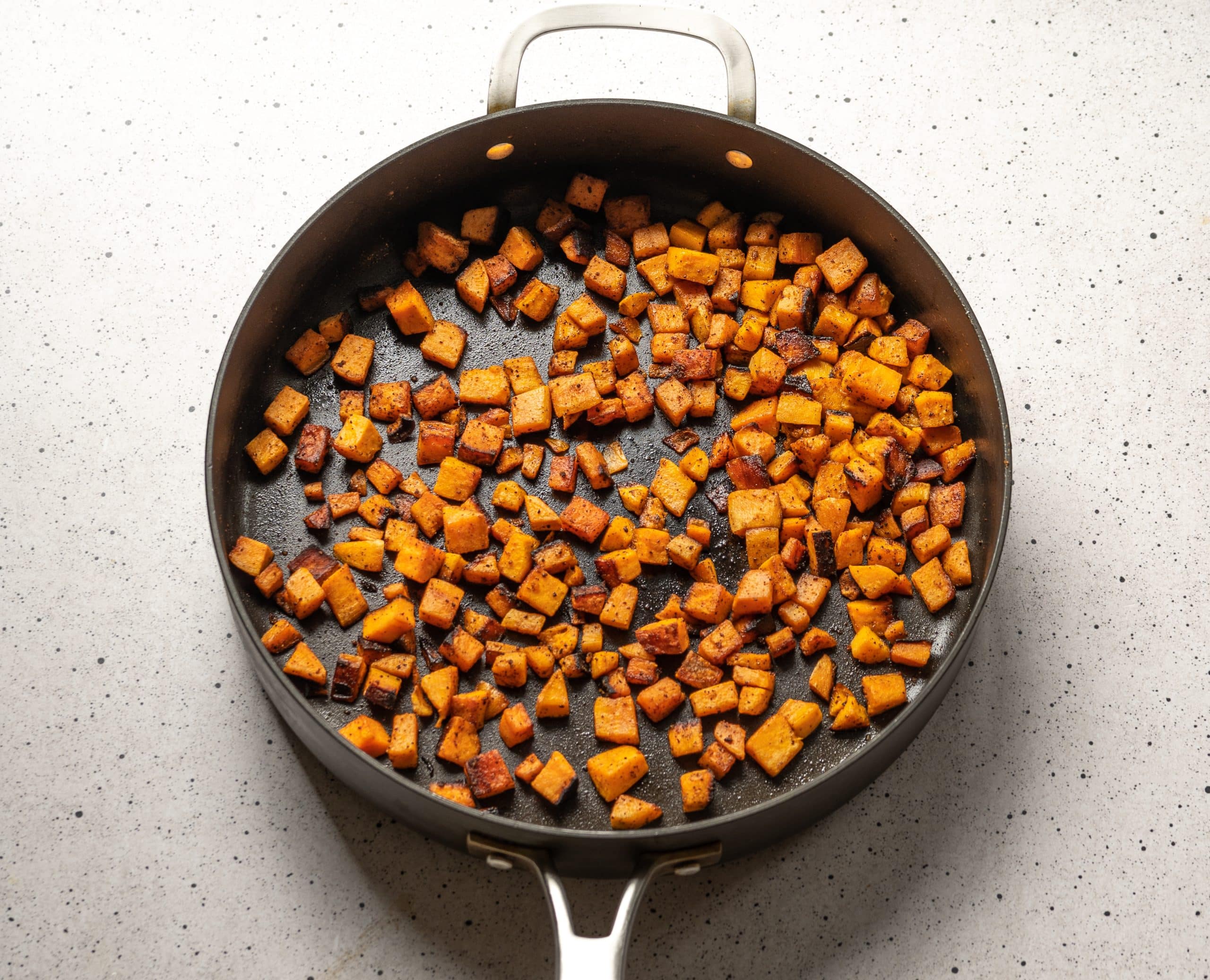 skillet with sauteed diced sweet potatoes