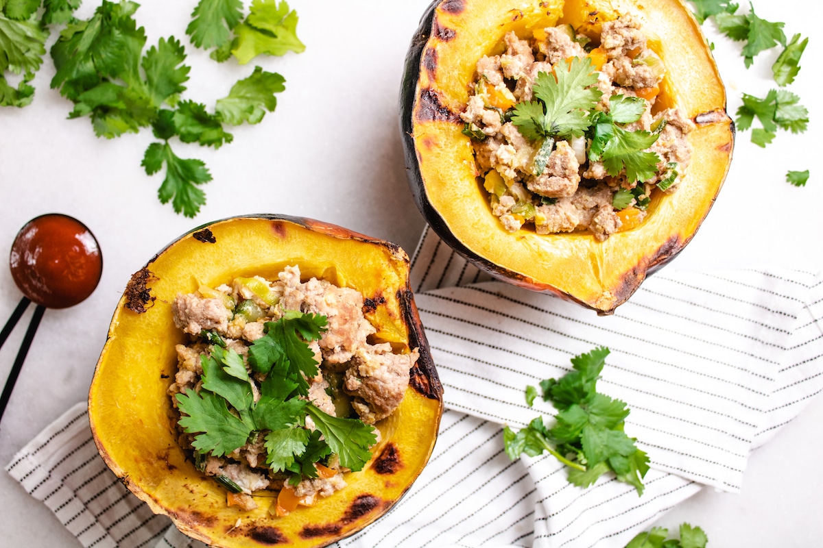 acorn squash stuffed with chorizo and cilantro on top with srirach scooped on the side