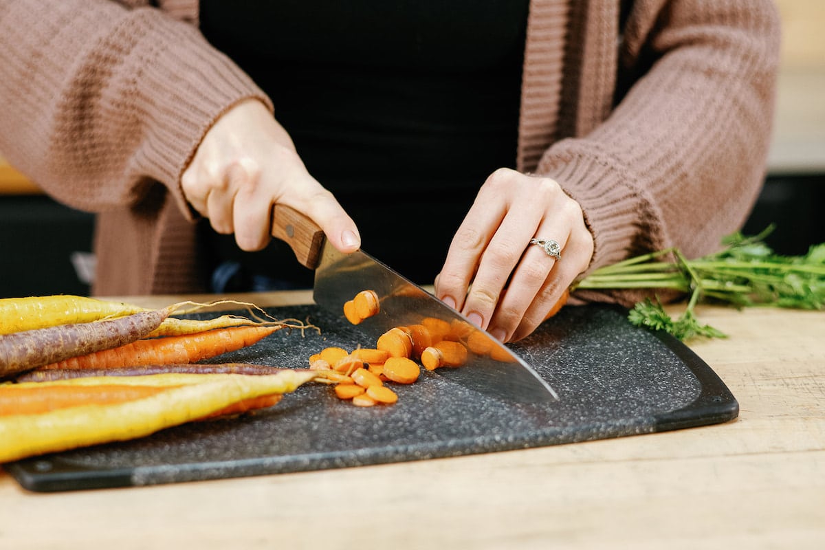 womans hands chopping carrots