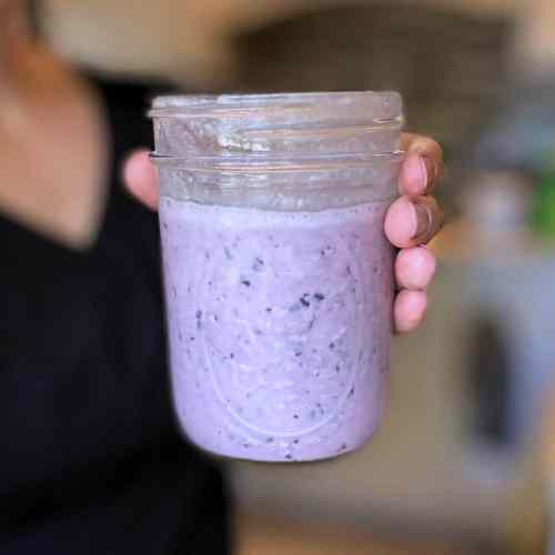 blueberry lemon smoothie in a jar held by woman