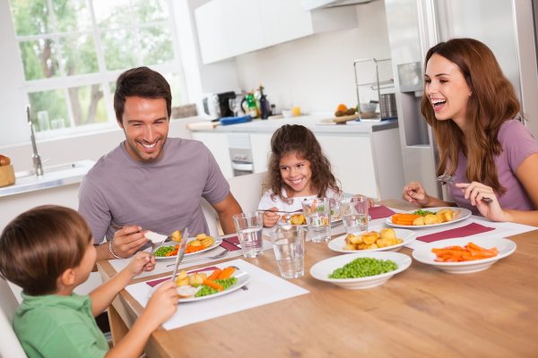 family gathered around table eating a meal served family style